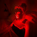 Person wearing a Fringe Red Light Therapy Face Mask in a dimly lit room