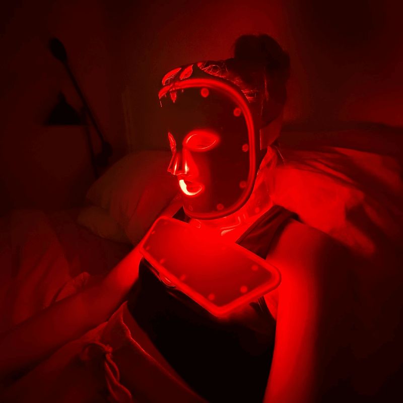 Person wearing a Fringe Red Light Therapy Face Mask in a dimly lit room