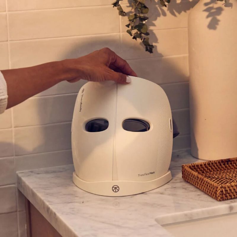 Person charging a Therabody Theraface LED Mask.